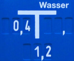 Blaues Schild mit der Aufschrift Wasser und einem Zeichenelement, ähnlich einem T mit drei Richtungweisern: links, rechts, unten. Am linken Bereich steht 0,4 am unteren 1,2