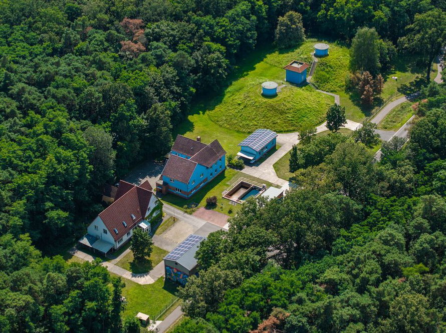 Wasserwerk Beeskow: Hauptgebäude links und Wasserwerksgebäude rechts, im Vordergrund ein Abflussbecken